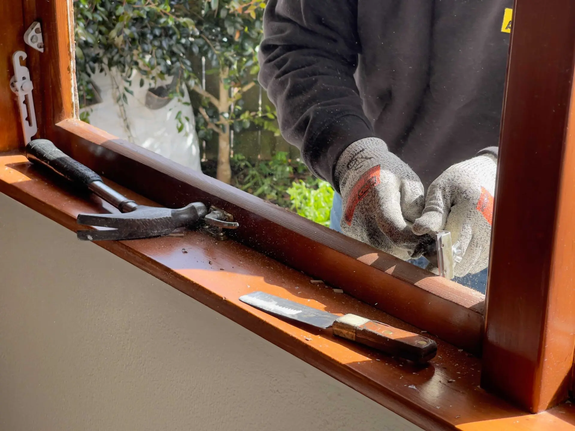 Schreiner bei der Reparatur und Einstellung eines Holzfensters