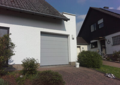 Modernes graues Garagentor an einem Wohnhaus