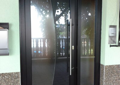 Dunkle Haustür mit mehreren horizontalen Glaselementen